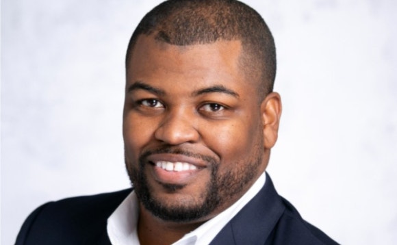 A person in a suit smiling AI-generated content may be incorrect.