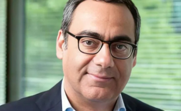A person wearing glasses and a suit AI-generated content may be incorrect.