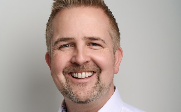 A person smiling for the camera AI-generated content may be incorrect.