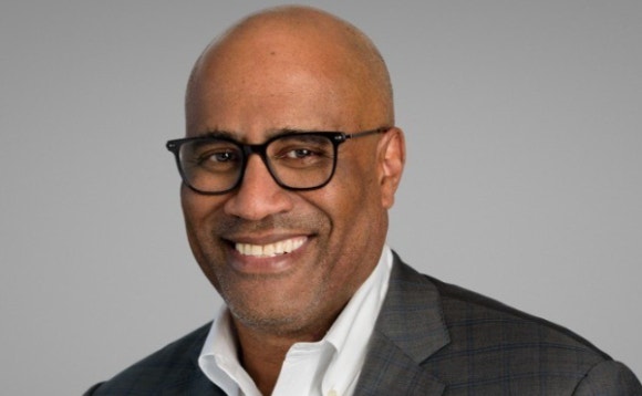 A person wearing glasses and a suit AI-generated content may be incorrect.
